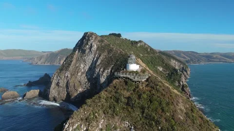Aerial drone view of Nugget Point lighthouse on coastal cliffs New Zealand Stock Footage 330950055