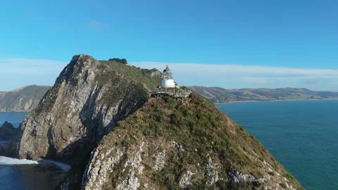 Aerial drone view of Nugget Point lighthouse on coastal cliffs New Zealand Video stock 330950057