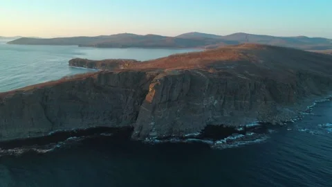 Aerial drone view of an ocean blue waves break on high cliff of a rocky mountain Stock Footage 146646938