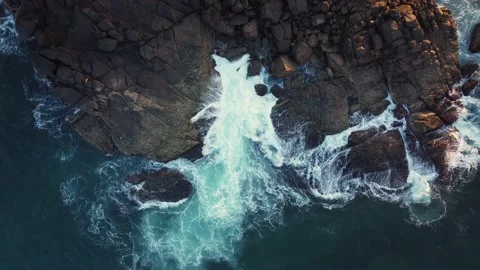 Aerial drone view of ocean blue waves break on high cliff of a rocky mountain Stock Footage 174643569