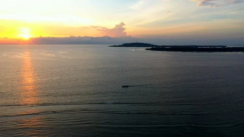 Aerial drone view of ocean with drifting fishing boat over amazing sunset Stock Footage 128001752