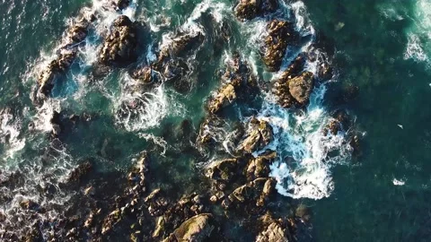 Aerial drone view of ocean waves crashing on rocks Stock Footage 149133944