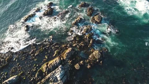Aerial drone view of ocean waves crashing on rocks on Pacific Coast Stock Footage 149133999