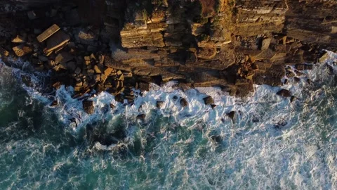 Aerial drone view of ocean waves crashing against the rocks of a cliff Stock Footage 220519857