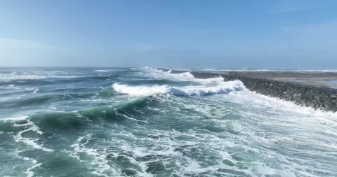 Aerial Drone View of Ocean Waves Crashing Against Rocky Jetty Stock Footage 320848629