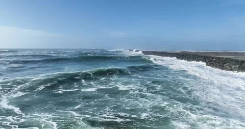 Aerial Drone View of Ocean Waves Crashing Against Rocky Jetty Stock Footage 320848645
