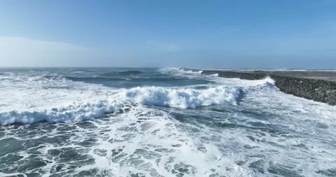 Aerial Drone View of Ocean Waves Crashing Against Rocky Jetty Stock Footage 320848656