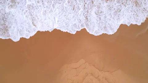 Aerial Drone View of Ocean Waves Crashing onto Orange Sandy Beach Coastline Stock Footage 339090831