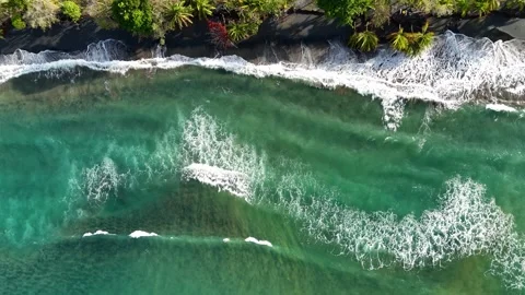 Aerial drone view of ocean waves crashing on black sand beach 库存影片 339118997