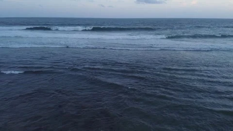 Aerial Drone View of Ocean Waves Rolling onto Sandy Beach at Sunrise Stock Footage 341454075