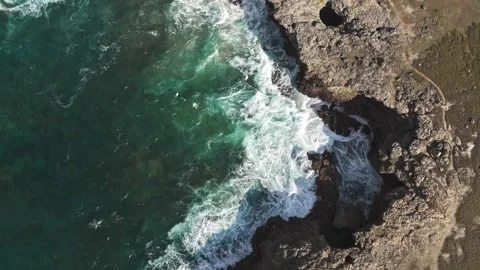 Aerial Drone View of Ocean Waves Crashing Into Rugged Rocky Coastline Vídeos de archivo 347639272