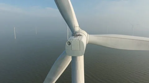 Aerial drone view of offshore wind turbines in the sea covered in thick fog. Stock Footage 336977742