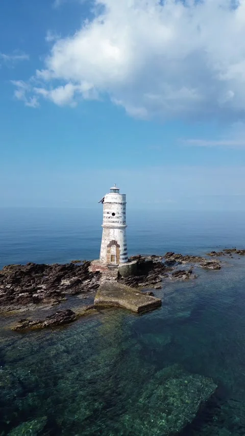 Aerial Drone View of Old Lighthouse Surrounded by Clear Blue Sea Stock-Footage 341597373