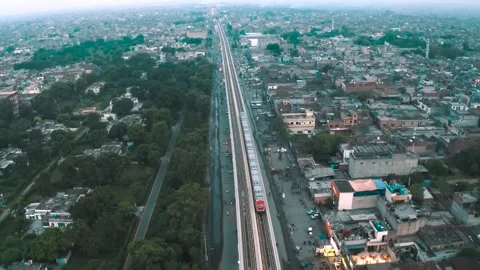 Aerial drone view of Orange Line Metro Train alongside Shalimar Gardens Stock Footage 346321901