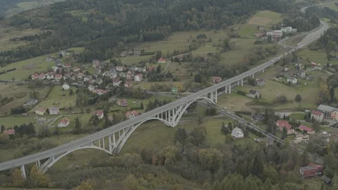 Aerial drone view over big bridge viaduct with green fields and houses around Stock Footage 104596812