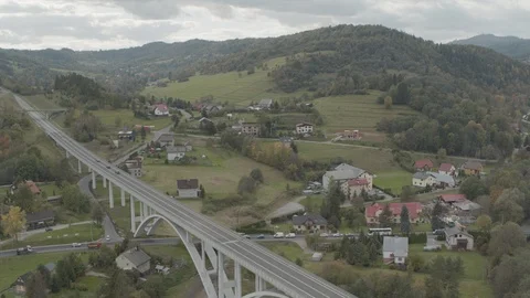 Aerial drone view over big bridge viaduct with green fields and houses around Stock Footage 104598033