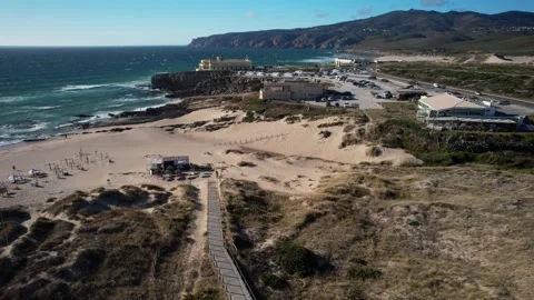 Aerial drone view of over Cresmina beach in Guincho, Portugal on a windy summer Stock Footage 245981996
