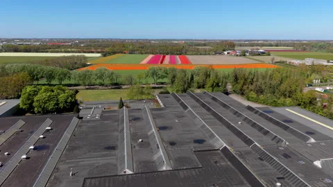 Aerial drone view over a large commercial warehouse roof with skylights Stock Footage 336216933