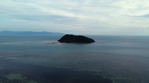 Aerial drone view over a small island in the calm sea at cloudy sunset Stock Footage 147006527