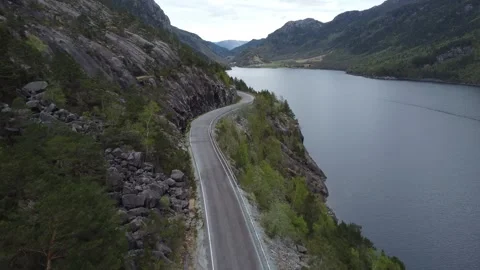 Aerial drone view over a winding country road along a Norwegian fjord surrounded Video stock 335198418
