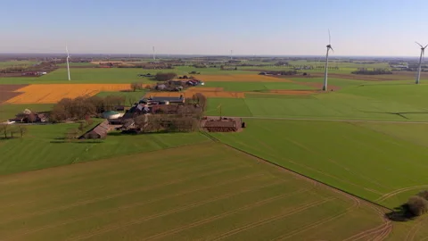 An aerial drone view overlooking a cluster of farm buildings and sprawling Stock Footage 336407238