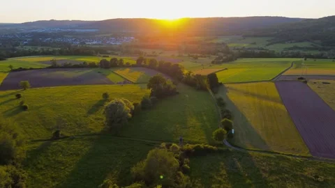 Aerial drone view of patchwork farmland at sunset with long shadows across Stock-Footage 336439123