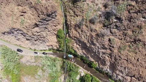 Aerial drone view of people bathing on a high waterfall falling on the road Stock Footage 171294965