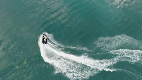 Aerial drone view of people having fun riding jet ski and making scenic stunts Stock Footage 115895319