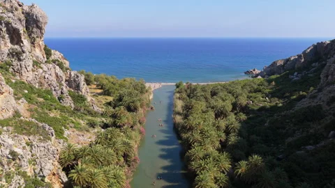 Aerial drone view of Preveli beach where the palm river meets the sea beside a Stock Footage 339300846
