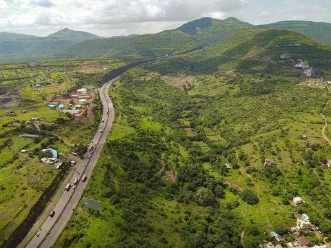 Aerial drone view of Pune Bangalore highway surrounded by green valley and mount Stock Photos