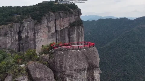 Aerial drone view of red railed observation deck in Zhejiang perched on rugged Stock Footage 336530060