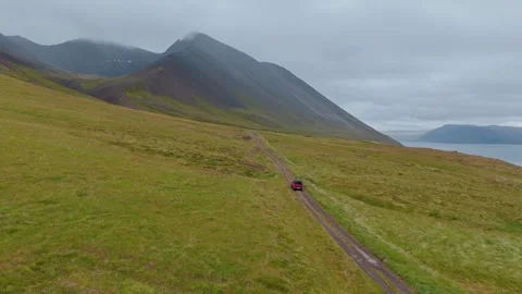 Aerial Drone View of Red SUV Driving on Svalvogaviti Road in Iceland Westfjords Stock Footage 341458338