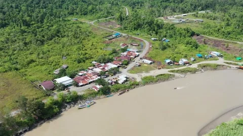 Aerial Drone View of Remote Tropical Village Settlement on Muddy River Bank Stock Footage 318537441