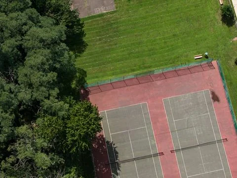 Aerial drone view of residential complex, parking areas, and mature trees in Stock-Fotos