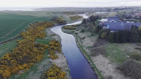 Aerial Drone View of River Flowing Through Countryside Near Town Video stock 333784457