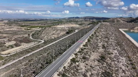 Aerial drone view of road on dam through dry landscape Stockbeeldmateriaal 340336948