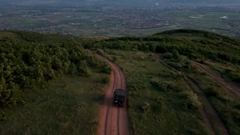Aerial Drone View of Off-Road SUV Driving on Mountain Trail Overlooking Valley Stock Footage 336856260