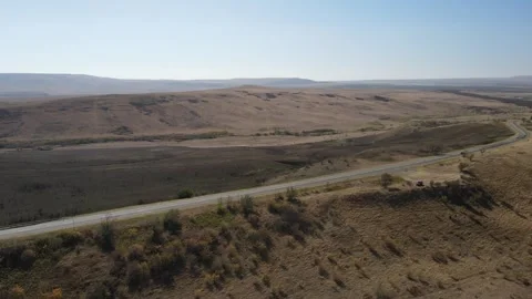 Aerial drone view of a road winding through an arid steppe landscape Video stock 337478958