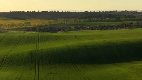 Aerial drone view of rolling green farmland with a small Czech village nestled Stock Footage 336625906