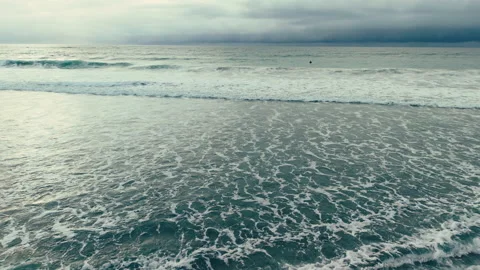 Aerial drone view of rolling ocean waves across Pacific Beach shoreline Video stock 339252347