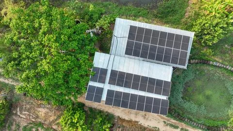 Aerial drone view of rooftop solar panel installation on rural farm buildin.. Stock Photos