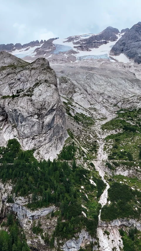 Aerial drone view of rugged alpine mountains with patches of snow and glacier Stock Footage 332312823