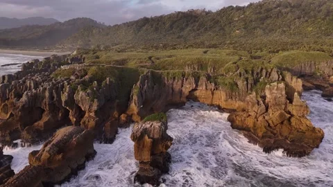 Aerial drone view of rugged coastal rock formations and crashing ocean waves 動画素材 345721648