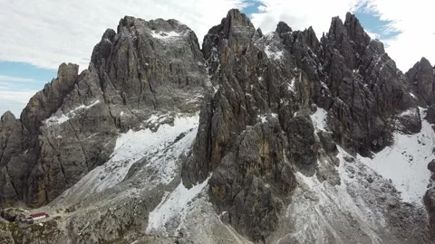Aerial drone view of rugged Dolomite mountain cliffs with snow, Italy Stock Footage 327865943