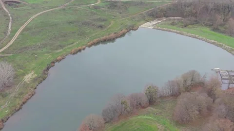 Aerial drone view of rural fields, dirt roads and calm water Stock Footage 323322285