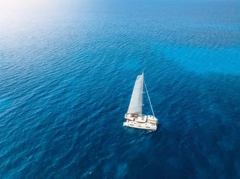Aerial drone view of sailing catamaran yacht moving in blue sea Stock Photos