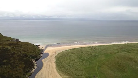 Aerial Drone View of Sandy Beach, Grassy Dunes, and Stream on Lewis, Scotland Stock Footage 346509398