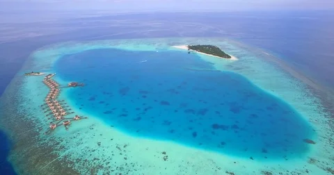 Aerial drone view of a scenic tropical island and resort hotel with overwater bu Stock Footage