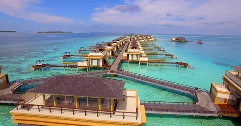 Aerial drone view of a scenic tropical island and resort hotel with overwater bu Stock Footage