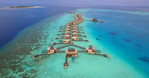 Aerial drone view of a scenic tropical island and resort hotel with overwater bu Stock Footage